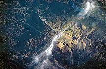 Image taken from a shuttle of Mount St. Helens showing destroyed area of the shattered cone of the mountain.  This image links to a more detailed image.